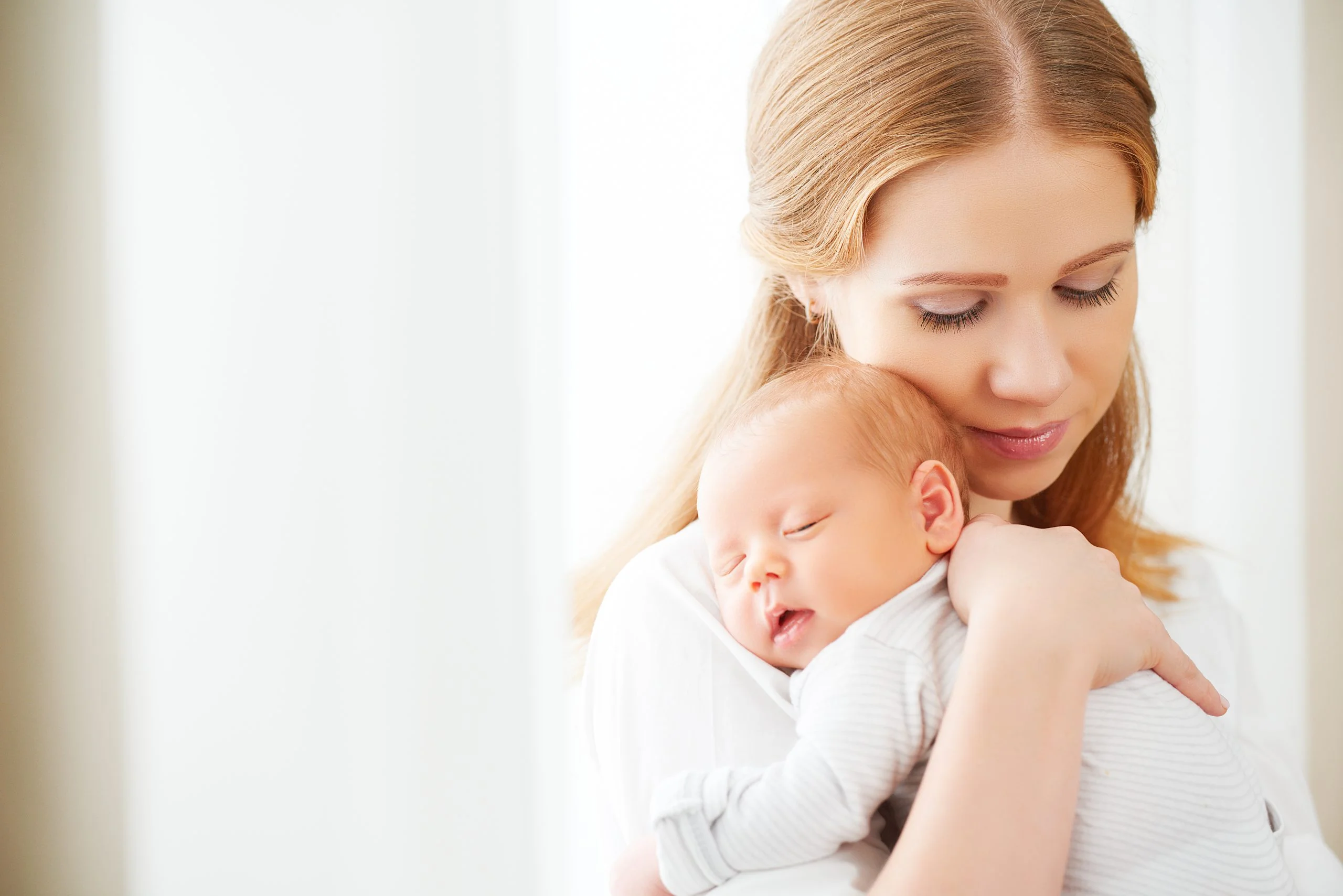 fiatal nő, karján csecsemőjével